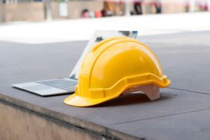 Casco y computadora conmemorando Día Mundial de la Seguridad y Salud en el Trabajo